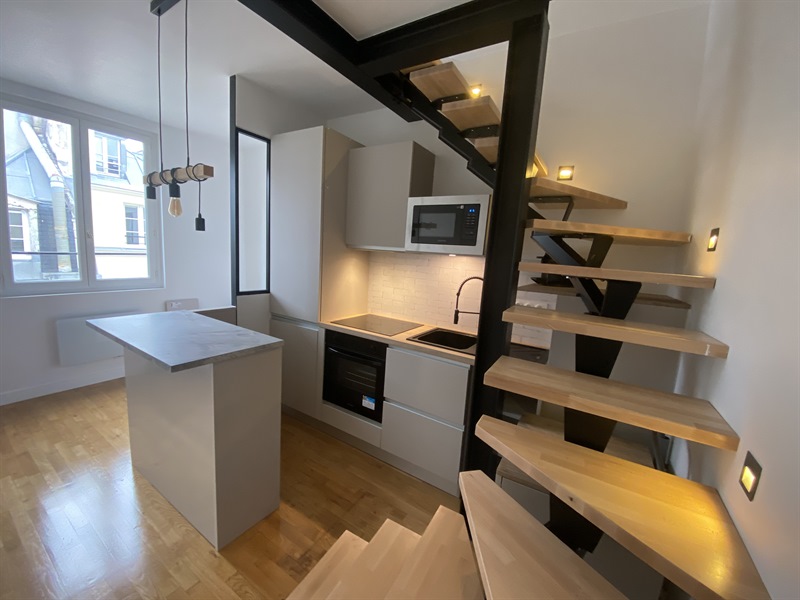 Cuisine ouverte de style industriel bois et beige à Paris | Raison Home